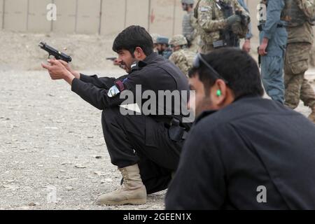 Uniformierte afghanische Polizisten, die in der Stadt Khost stationiert sind, feuern M-9 Beretta-Pistolen auf einen kleinen Waffenbereich auf Camp Parsa, Provinz Khowst, Afghanistan, 30. Januar 2013. Soldaten der US-Armee, die dem Team 28 der Sicherheitskräfte, der Task Force 3/101, zugewiesen wurden, planten die Reichweite und unterstützten die AUP beim sicheren Üben mit ihren Waffen. (USA Armeefoto von Sgt. Kimberly Trumbull / Veröffentlicht) Stockfoto