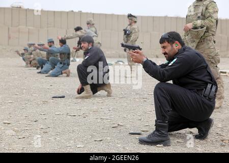 Uniformierte afghanische Polizisten, die in der Stadt Khost stationiert sind, feuern M9 Beretta-Pistolen auf einen Kleinwaffenbereich im Lager Parsa, Provinz Khowst, Afghanistan, 30. Januar 2013. Soldaten der US-Armee, die dem Team 28 der Sicherheitskräfte, der Task Force 3/101, zugewiesen wurden, planten die Reichweite und unterstützten die AUP beim sicheren Üben mit ihren Waffen. (USA Armeefoto von Sgt. Kimberly Trumbull / Veröffentlicht) Stockfoto