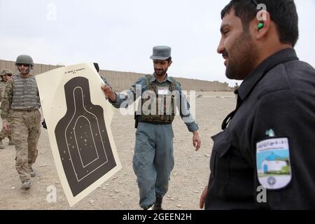 Ein in der Stadt Khost stationierter afghanischer uniformierte Polizist zeigt sein Ziel, nachdem er eine M-9-Beretta-Pistole auf einem kleinen Waffenlager in Camp Parsa, Provinz Khowst, Afghanistan, abgefeuert hat, 30. Januar 2013. Soldaten der US-Armee, die dem Team 28 der Sicherheitskräfte, der Task Force 3/101, zugewiesen wurden, planten die Reichweite und unterstützten die AUP beim sicheren Üben mit ihren Waffen. (USA Armeefoto von Sgt. Kimberly Trumbull / Veröffentlicht) Stockfoto