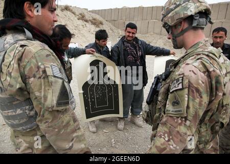 Afghanische uniformierte Polizisten, die in der Stadt Khost stationiert sind, zeigen ihre Ziele, nachdem sie AK-47-Gewehre auf einem kleinen Waffenlager in Camp Parsa, Provinz Khowst, Afghanistan, abgefeuert haben, 30. Januar 2013. Soldaten der US-Armee, die dem Team 28 der Sicherheitskräfte, der Task Force 3/101, zugewiesen wurden, planten die Reichweite und unterstützten die AUP beim sicheren Üben mit ihren Waffen. (USA Armeefoto von Sgt. Kimberly Trumbull / Veröffentlicht) Stockfoto