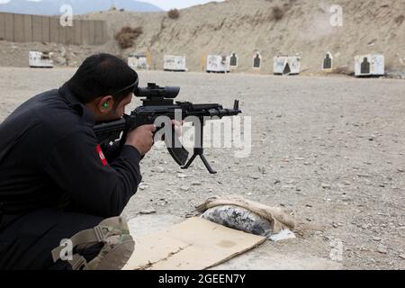 Ein in der Stadt Khost stationierter afghanischer uniformierte Polizist feuert sein AK-47-Gewehr auf einen kleinen Waffenbereich auf Lager Parsa, Provinz Khowst, Afghanistan, 30. Januar 2013. Soldaten der US-Armee, die dem Team 28 der Sicherheitskräfte, der Task Force 3/101, zugewiesen wurden, planten die Reichweite und unterstützten die AUP beim sicheren Üben mit ihren Waffen. (USA Armeefoto von Sgt. Kimberly Trumbull / Veröffentlicht) Stockfoto