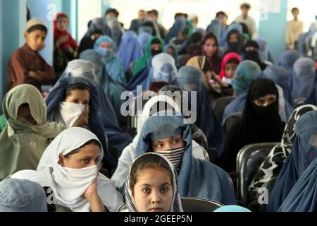 Lokale Frauen hören einem Redner bei einem Treffen zum Internationalen Frauentag im Hauptquartier der Provinz Khost in der Stadt Khost, Provinz Khost, Afghanistan, am 9. März 2013 zu. Das Treffen war eines der größten Frauenversammlungen, die je in der Provinz Khost stattfinden. Sie diskutierten über die Stärke und Verantwortung einer Frau in ihrem Haushalt sowie über die Hochschulbildung für alle Frauen und Mädchen. (USA Armeefoto von Sgt. Kimberly Trumbull / Veröffentlicht) Stockfoto