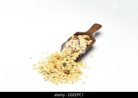 Gesundes Müsli und Cornflakes Frühstück. Gemischter Müsli aus Holzschaufel isoliert auf weißem Grund. Stockfoto