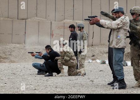 Uniformierte afghanische Polizisten, die in der Stadt Khost stationiert sind, feuern M9 Beretta-Pistolen auf einen Kleinwaffenbereich im Lager Parsa, Provinz Khowst, Afghanistan, 30. Januar 2013. Soldaten der US-Armee, die dem Team 28 der Sicherheitskräfte, der Task Force 3/101, zugewiesen wurden, planten die Reichweite und unterstützten die AUP beim sicheren Üben mit ihren Waffen. (USA Armeefoto von Sgt. Kimberly Trumbull / Veröffentlicht) Stockfoto