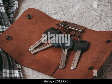 Nahaufnahme eines geöffneten braunen Lederschlüsselhalters mit Schlüsseln Stockfoto