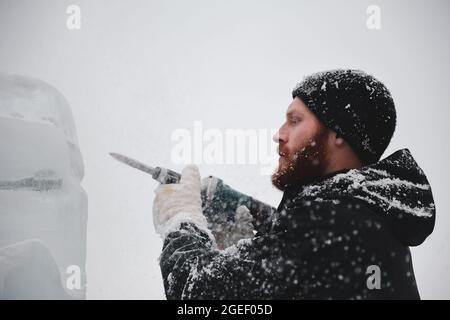 Professioneller Eisschnitzer, der Eisklotz modelliert Stockfoto