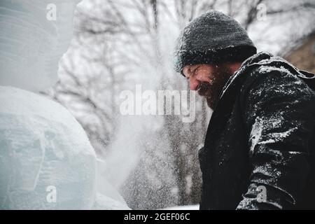 Professioneller Eisschnitzer, der Eisklotz modelliert Stockfoto