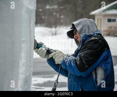 Professioneller Eisschnitzer, der Eisklotz modelliert Stockfoto