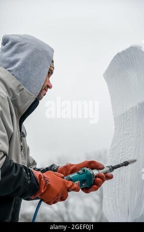 Professioneller Eisschnitzer, der Eisklotz modelliert Stockfoto