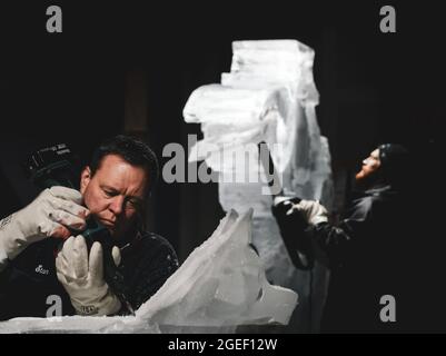 Professioneller Eisschnitzer, der Eisklotz modelliert Stockfoto