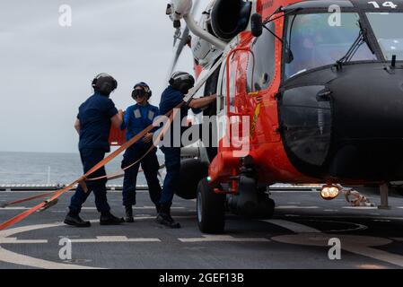 Küstenwache, Kleinoffizier der 3. Klasse, Maya Hedlesky, eine Spezialistin für Operationen, eskortiert Vize-ADM. Michael McAllister, Kommandooffizier Pacific Area und Master Chief Petty Officer Lucas Pullen Command Master Chief Petty Officer Pacific Area, an Bord des Küstenwache-Cutter Munro im Pazifischen Ozean, 25. Juli 2021. Vice Adm. McAllister und Master Chief Petty Officer Pullen besuchten die Mitglieder an Bord des Küstenwache-Schneidermeisters Munro, bevor sie sich in den westlichen Pazifik aufmachten. (USA Marine Corps Foto von Sgt. Kevin G. Rivas) Stockfoto