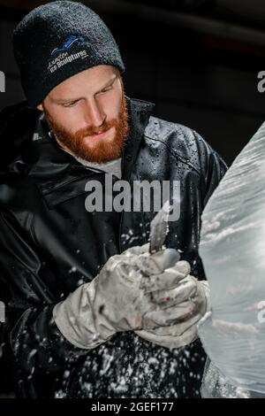 Professioneller Eisschnitzer, der Eisklotz modelliert Stockfoto