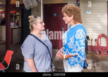 NEW ORLEANS, LA, USA - 18. JULI 2021: Ältere Frauen unterhalten sich im Restaurant im Freien Stockfoto
