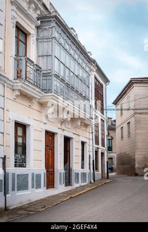 Castropol, Spanien; 25. Juli 2021: Fassade eines Hauses aus dem frühen 20. Jahrhundert mit einem schönen Balkon, in einer Straße im asturischen Dorf Castropol. Stockfoto