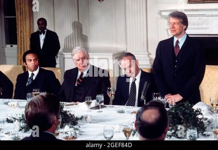 Der Präsident der Vereinigten Staaten, Jimmy Carter, rechts, hält am Montag, den 7. März 1977, bei einem Arbeitsessen zu Ehren des israelischen Ministerpräsidenten Yitzhak Rabin, rechts in der Mitte, im Staatlichen Speisesaal des Weißen Hauses in Washington, DC, eine Rede. Ein Blick darauf ist der Sprecher des US-Repräsentantenhauses, Tip ONeill (Demokrat von Massachusetts), links in der Mitte, und der US-Botschafter bei den Vereinten Nationen, Andrew Young. Quelle: Benjamin E. 'Gene' Forte/CNP Stockfoto