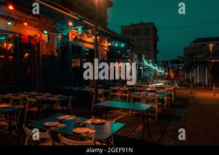 JERUSALEM, ISRAEL - 16. Jul 2021: Eine malerische Aussicht auf leere Stühle und Bänke in einem Straßenrestaurant in Jerusalem, Israel Stockfoto