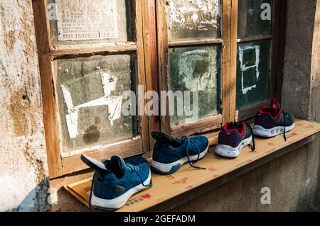 Schuhe auf einem Fensterbrett trocknen im unentwickelten alten Teil der Altstadt von Qibao im Minhang District, Shanghai, China. Stockfoto