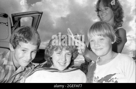 CROW'S NEST, QUEENSLAND, AUSTRALIEN, MAI 1984: Ein nicht identifizierter Friseur beendet einen Job für drei aufgeregte Kinder auf der jährlichen A und P Show in Crow's Nest, Queensland, 1984. Gescannt von Originalnegativen für die Zeitungsveröffentlichung. Stockfoto