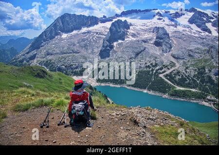 Ältere Frau sitzt auf dem Berggipfel mit schöner Aussicht im Hintergrund Stockfoto