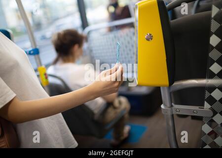 Asiatische Frau, die mit Plastikkarte für die öffentlichen Verkehrsmittel in Bus, Straßenbahn oder U-Bahn-Fahrzeug ohne Konzetszahlung bezahlt Stockfoto