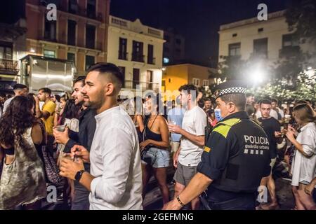 Barcelona, Spanien. August 2021. Polizisten werden gesehen, wie sie Menschen auf der Plaza del Sol, einem Platz im Stadtteil Gracia von Barcelona, zerstreuen.der Oberste Gerichtshof von Katalonien (TSJC) hat am Donnerstag, dem 19. August, das Ende der Ausgangssperre in Barcelona, Zeitgleich mit der Woche, in der das traditionelle Fest des Viertels Gracia gefeiert wird. Die häufigen Menschenmengen, die auf der Straße trinken, haben die ganze Nacht über gedauert, obwohl die Polizei an einigen Stellen Räumungen durchgeführt hat. Kredit: SOPA Images Limited/Alamy Live Nachrichten Stockfoto