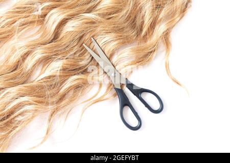 Schöne blonde Haare und offene Friseurschere Draufsicht. Haarschneidekonzept Stockfoto