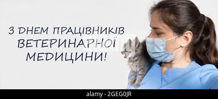 Banner in Ukrainisch, Übersetzung Welttiertag. Tierarzt und Kätzchen, Katze. Stockfoto