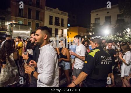 Barcelona, Katalonien, Spanien. August 2021. Der Oberste Gerichtshof Kataloniens (TSJC) hat am Donnerstag, dem 19. August, das Ende der Ausgangssperre in Barcelona festgelegt, zeitgleich mit der Woche, in der das traditionelle Fest des Viertels Gracia gefeiert wird. Die häufigen Menschenmengen, die auf der Straße trinken, haben die ganze Nacht über gedauert, obwohl die Polizei an einigen Stellen Räumungen durchgeführt hat. (Bild: © Thiago Prudencio/DAX via ZUMA Press Wire) Stockfoto