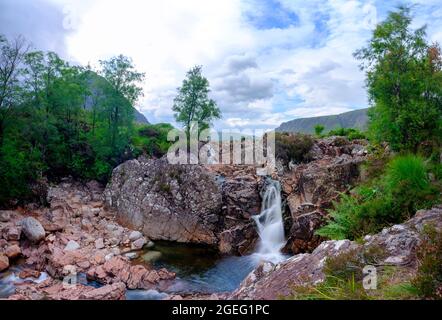 Glen Coe, Schottland - 5. August 2021: Der Wasserfall auf dem Fluss Coupall mit Buachaille Etive Mor, Schottland Stockfoto