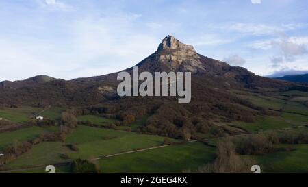 Schöne Aussicht auf felsige Bergwälder und grüne Felder unter einem bewölkten Himmel in Navarra, Spanien Stockfoto