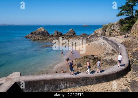 Saint Malo (Bretagne, Nordwestfrankreich): Touristen auf dem Küstenweg, der vom Strand „Plage du Pont“ zur Landzunge „pointe de la Varde“ führt Stockfoto