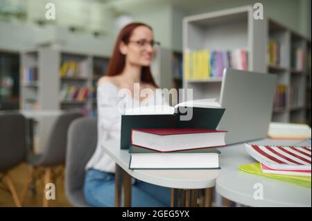 Eine Wissenschaftlerin, die in einer öffentlichen Bibliothek wissenschaftliche Forschungen macht Stockfoto