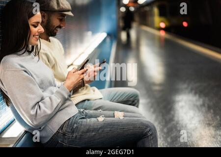 Junges Paar mit Mobiltelefonen in U-Bahn-U-Bahn - Fokus auf Mädchen Hände Stockfoto