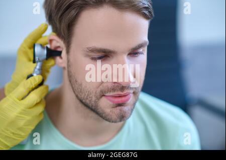 Männliche Patienten Ohrtrommel, die mit einem Otoskop untersucht wird Stockfoto