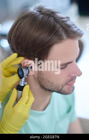 Junge Patienten hören, die mit einem Ohrhörer untersucht werden Stockfoto