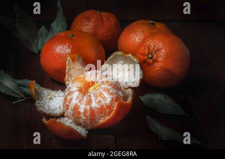 Mandarinen in Masse auf einem groben Stoff, in einem dunklen rustikalen Stil Stockfoto