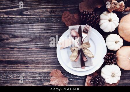 Ein Ferienort mit Teller, Serviette, an einem Thanksgiving Day dekorierten Tisch, der aus flacher Lay- oder Draufsicht-Position geschossen wurde. Besteck mit Gold gebunden r Stockfoto