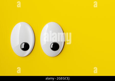Lustige, schöne oder wackelige Augen, die nach rechts auf gelbem Hintergrund schauen, minimales Konzept, 3D-Illustration Stockfoto