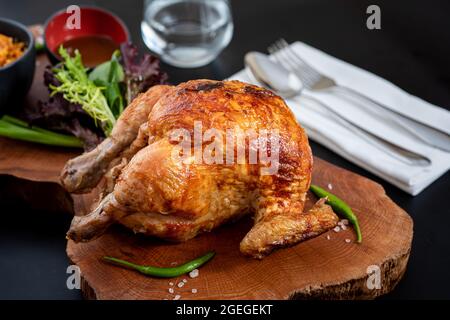 Gebratenes ganzes Huhn auf Holzkohle mit Bulgur-Pilaf auf Holzbrett gekocht. Stockfoto