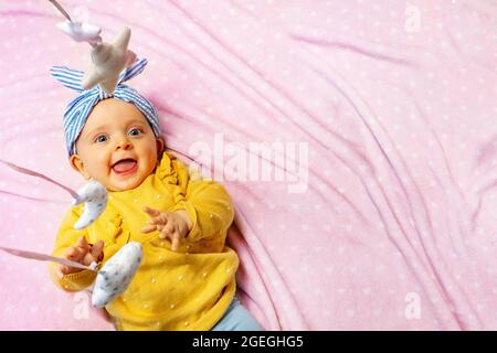 Baby Mädchen lachen mit mobilen Spielzeug Blick von oben Stockfoto