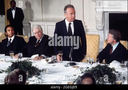 Der israelische Premierminister Yitzhak Rabin, rechts in der Mitte, hält am Montag, den 7. März 1977, bei einem Arbeitsessen zu seinen Ehren, das der US-Präsident Jimmy Carter, rechts, im Staatlichen Speisesaal des Weißen Hauses in Washington, DC, veranstaltet hat, eine Rede. Im Blick: Der Sprecher des US-Repräsentantenhauses, Tip O'Neill (Demokrat von Massachusetts), links in der Mitte, und der US-Botschafter bei den Vereinten Nationen, Andrew Young.Quelle: Benjamin E. 'Gene' Forte/CNP/Sipa USA Quelle: SIPA USA/Alamy Live News Stockfoto