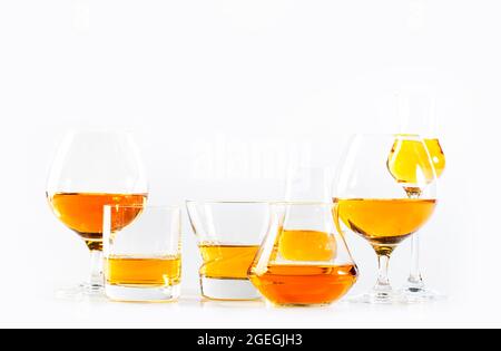 Starke Alkoholgetränke, harte Spirituosen, Spirituosen und Destillate iset in Gläsern: cognac, Scotch, Whiskey und andere. Weißer Hintergrund Stockfoto