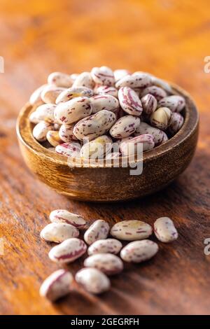 Cranberry-Bohnen. Borlotti Bohnen in Schüssel auf Holztisch. Stockfoto