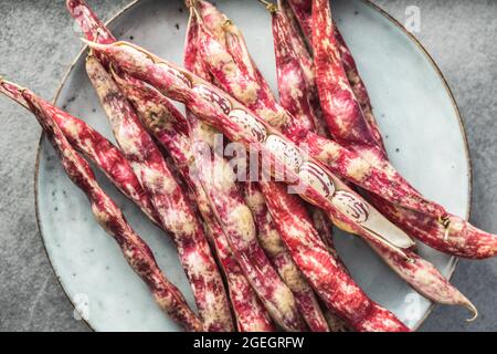 Cranberry-Bohnen. Borlotti-Bohnen. Bohnen-Pads auf dem Teller. Draufsicht. Stockfoto