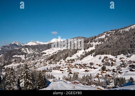 La Clusaz (Alpen, Mittelostfrankreich): Berglandschaft mit schneebedeckten Chalets im Skigebiet, von der Straße zum pa betrachtet Stockfoto