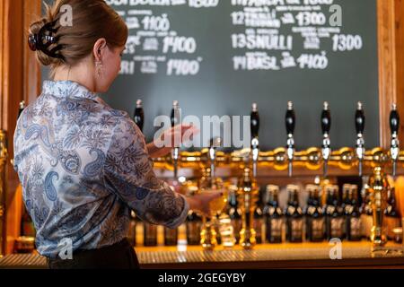 Weibliche Barkeeperin gießt Bier vom Fass Stockfoto