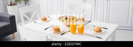 Orangensaft, leckere Pfannkuchen und frisches Obst auf weißem Küchentisch, Banner Stockfoto