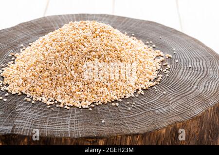 Roh getrocknet gebrochen Gerste Getreide Getreide Textur Hintergrund Makro Nahaufnahme. Gerstengroats, grober Gerstengrieß. Stockfoto