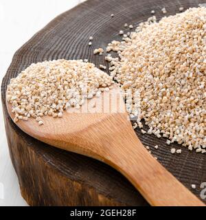 Roh getrocknet gebrochen Gerste Getreide Getreide Textur Hintergrund Makro Nahaufnahme. Gerstengroats, grober Gerstengrieß. Stockfoto