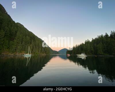 Boote in einem ruhigen Ankerplatz bei Sonnenuntergang, British Columbia, Kanada Stockfoto